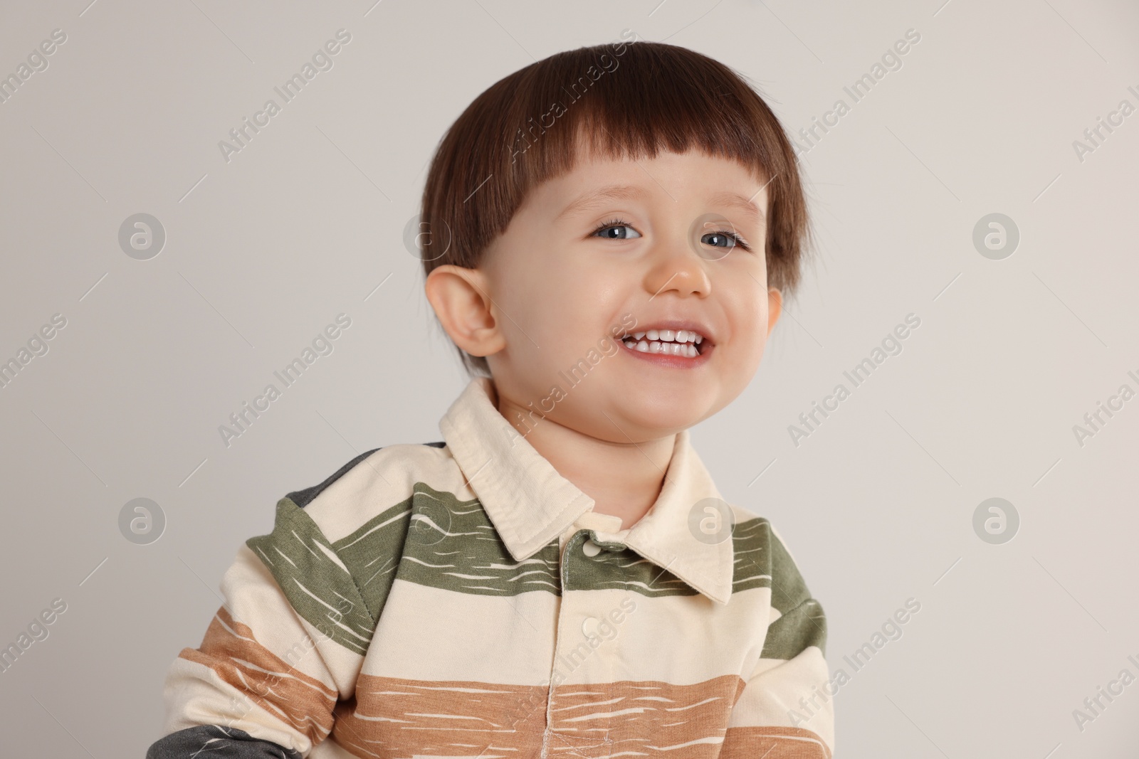 Photo of Portrait of happy little boy on light grey background