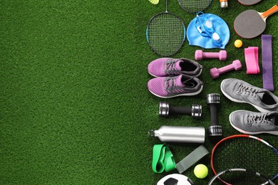 Photo of Different sport equipment on artificial grass, flat lay. Space for text