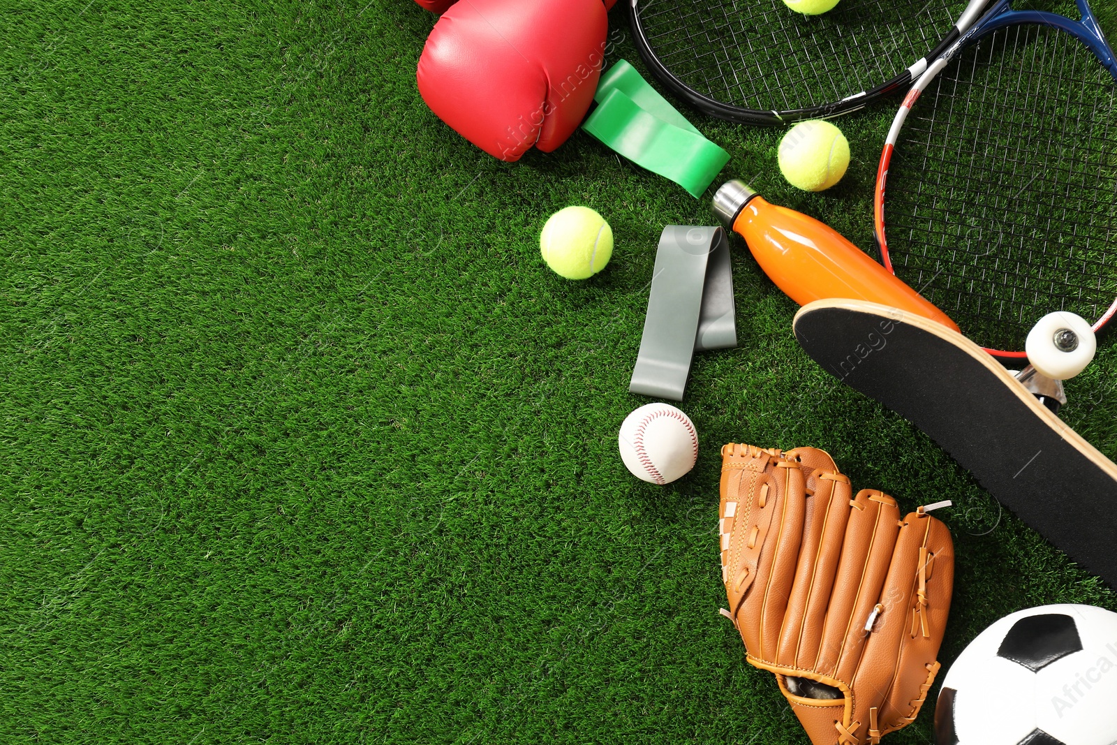 Photo of Different sport equipment on artificial grass, flat lay. Space for text