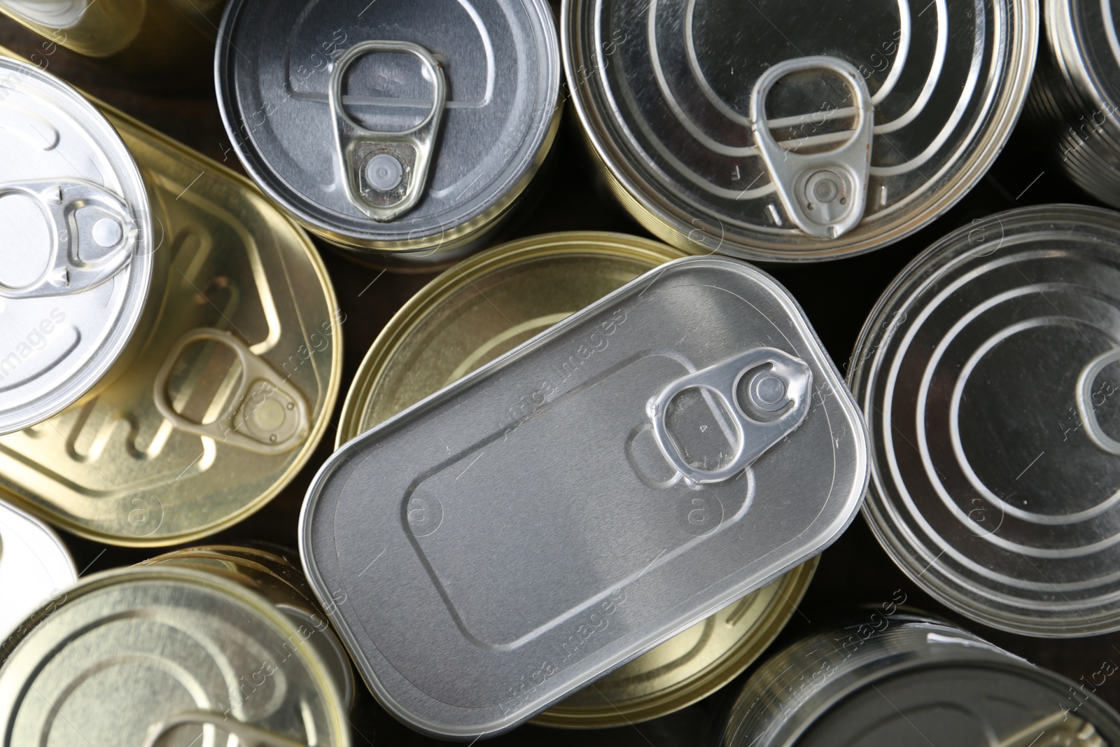 Photo of Many closed tin cans on wooden table, flat lay