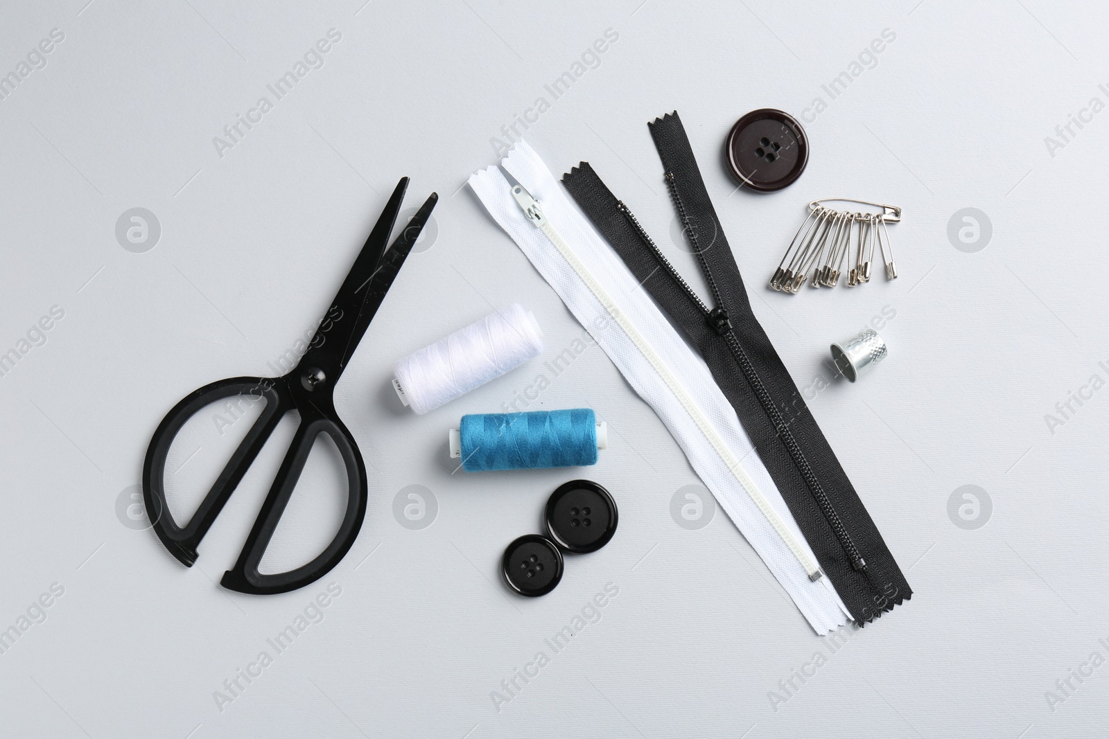 Photo of Different sewing supplies on white background, flat lay