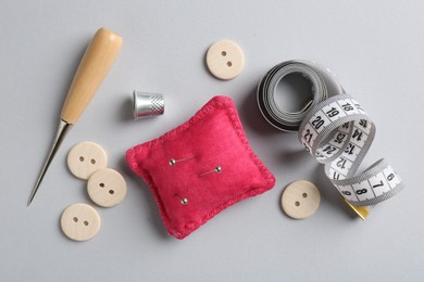 Photo of Different sewing supplies on light grey background, flat lay