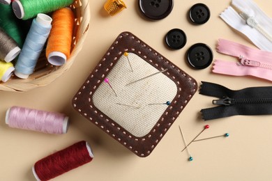 Photo of Different sewing supplies on beige background, flat lay