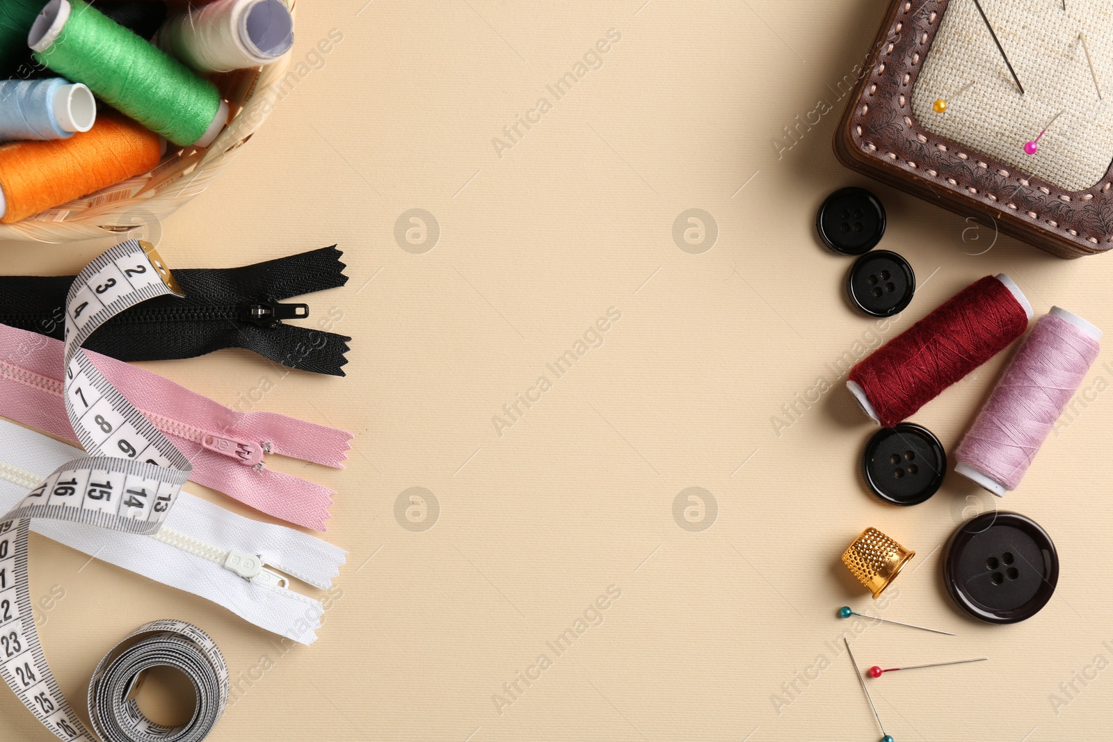 Photo of Frame of different sewing supplies on beige background, flat lay. Space for text