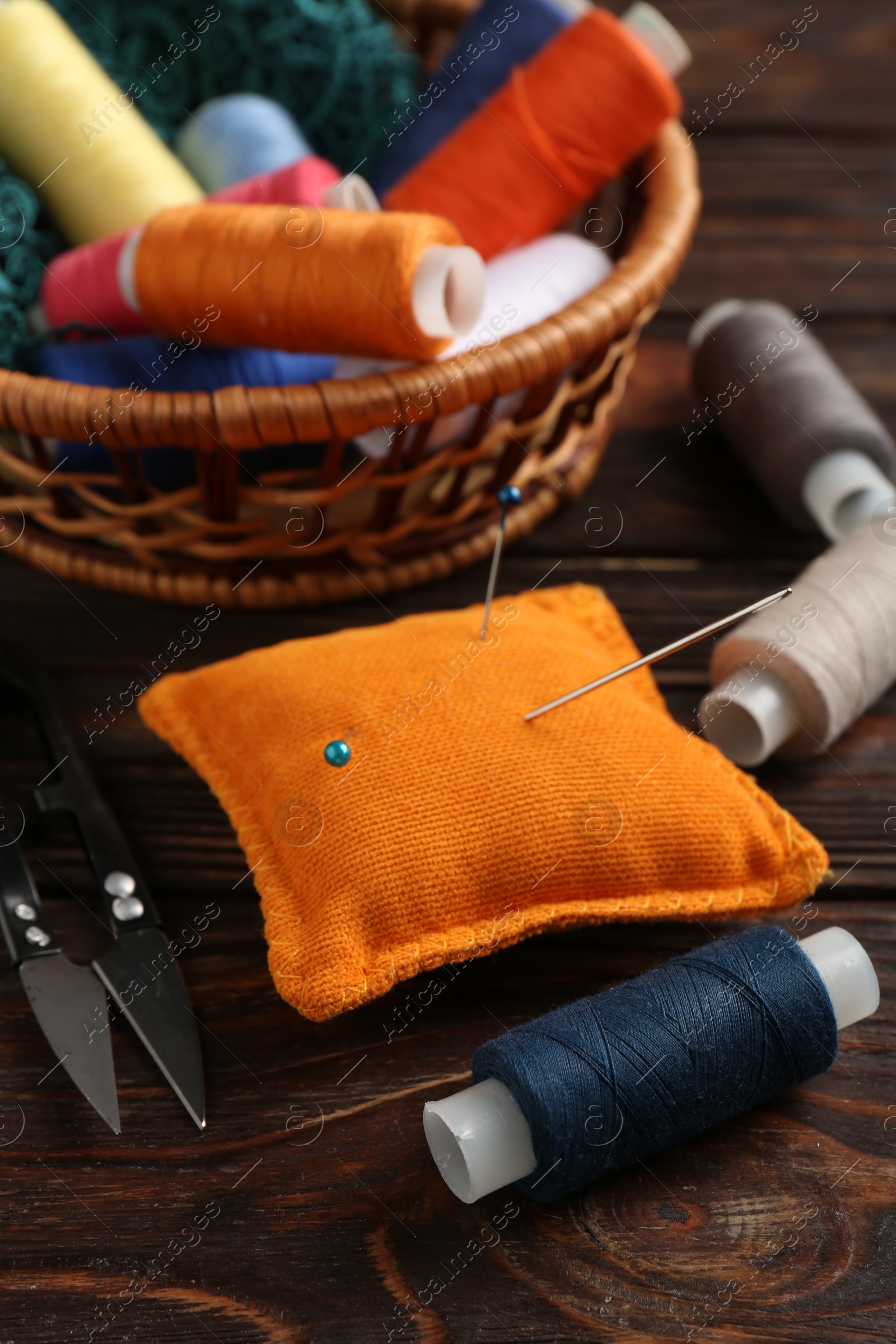 Photo of Different sewing supplies on wooden background, closeup