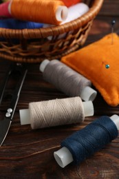 Photo of Different sewing supplies on wooden background, closeup