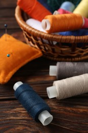 Photo of Different sewing supplies on wooden background, closeup