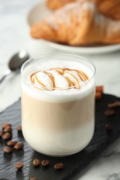 Photo of Tasty latte macchiato in glass on marble table, closeup. Coffee drink