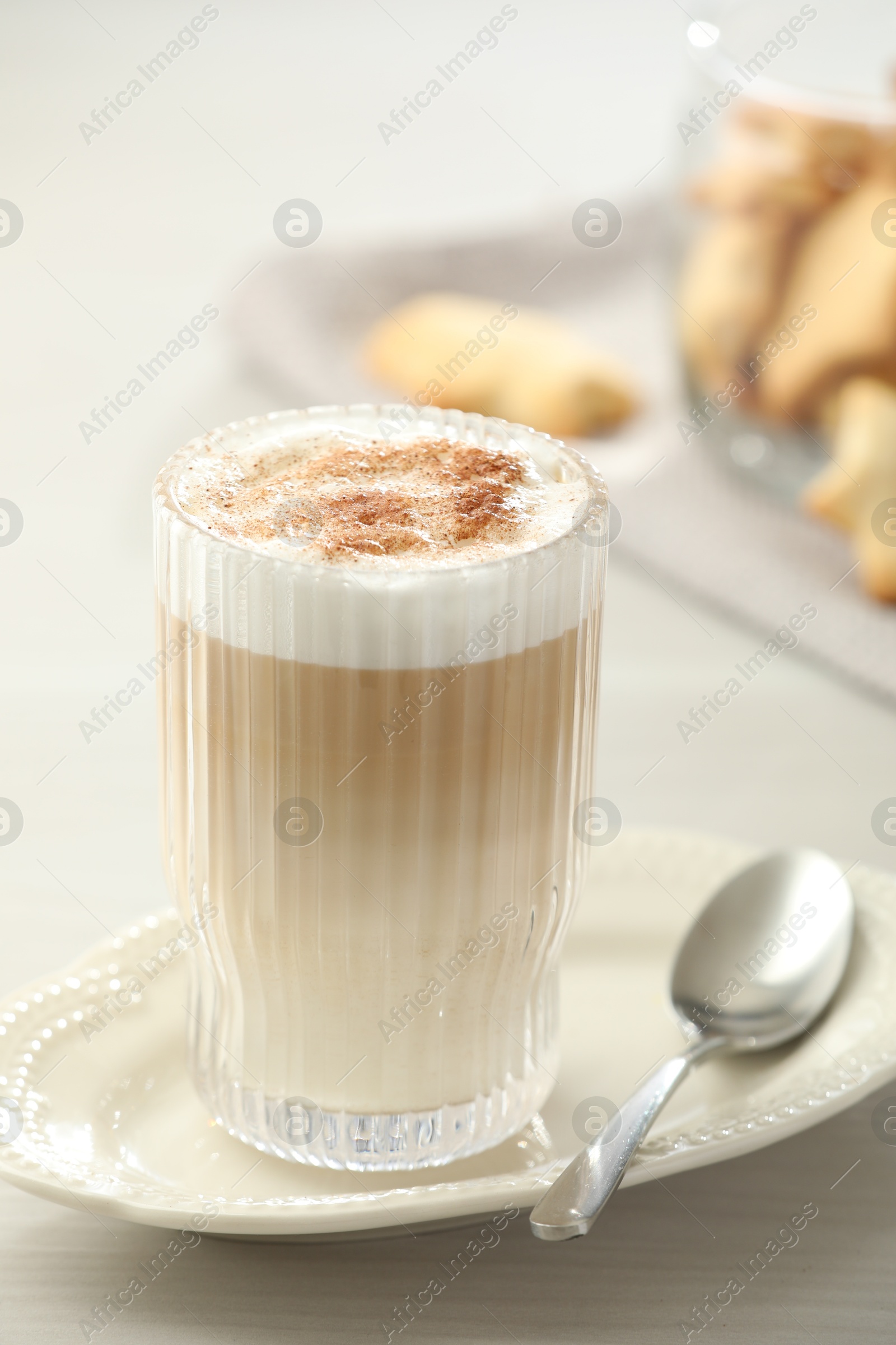 Photo of Tasty latte macchiato in glass on white table, closeup. Coffee drink