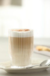 Photo of Tasty latte macchiato in glass on white table, closeup. Coffee drink