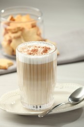 Photo of Tasty latte macchiato in glass on white table, closeup. Coffee drink