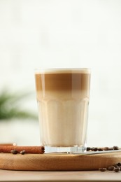 Photo of Tasty latte macchiato in glass on wooden table, closeup. Space for text