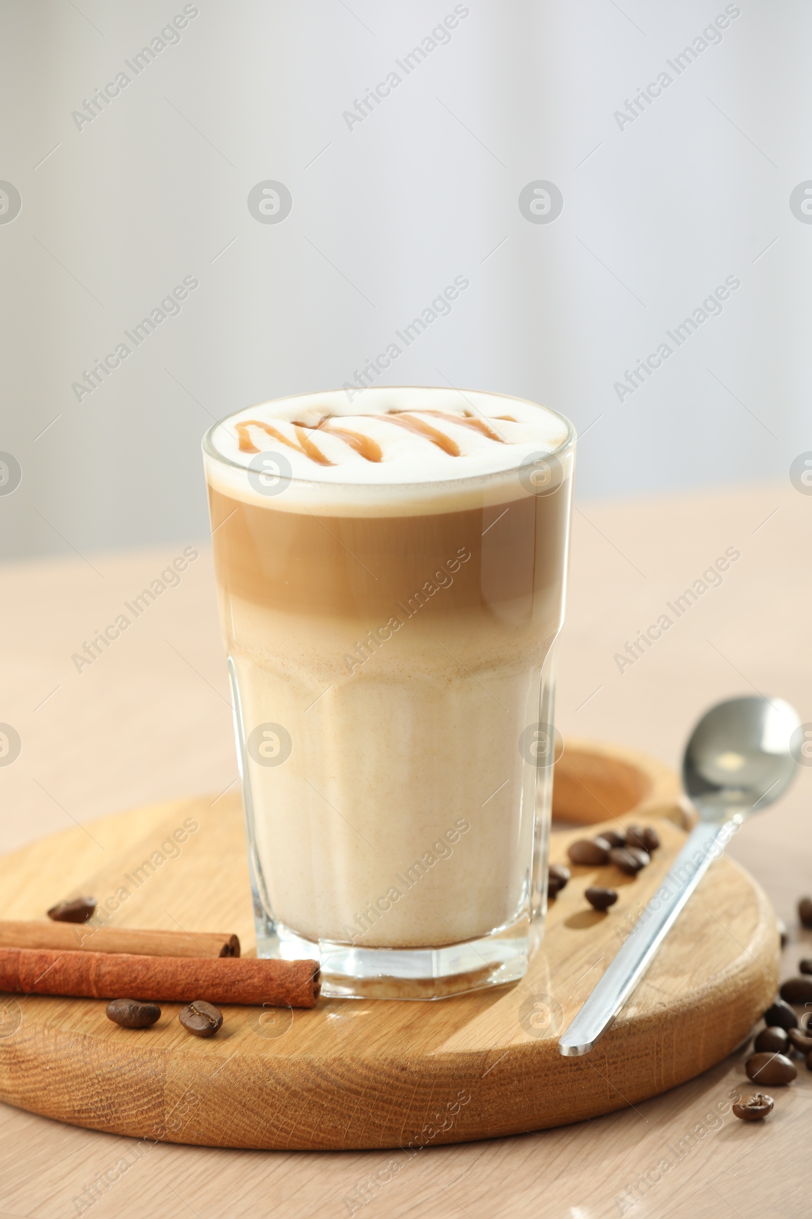 Photo of Tasty latte macchiato in glass on wooden table, closeup