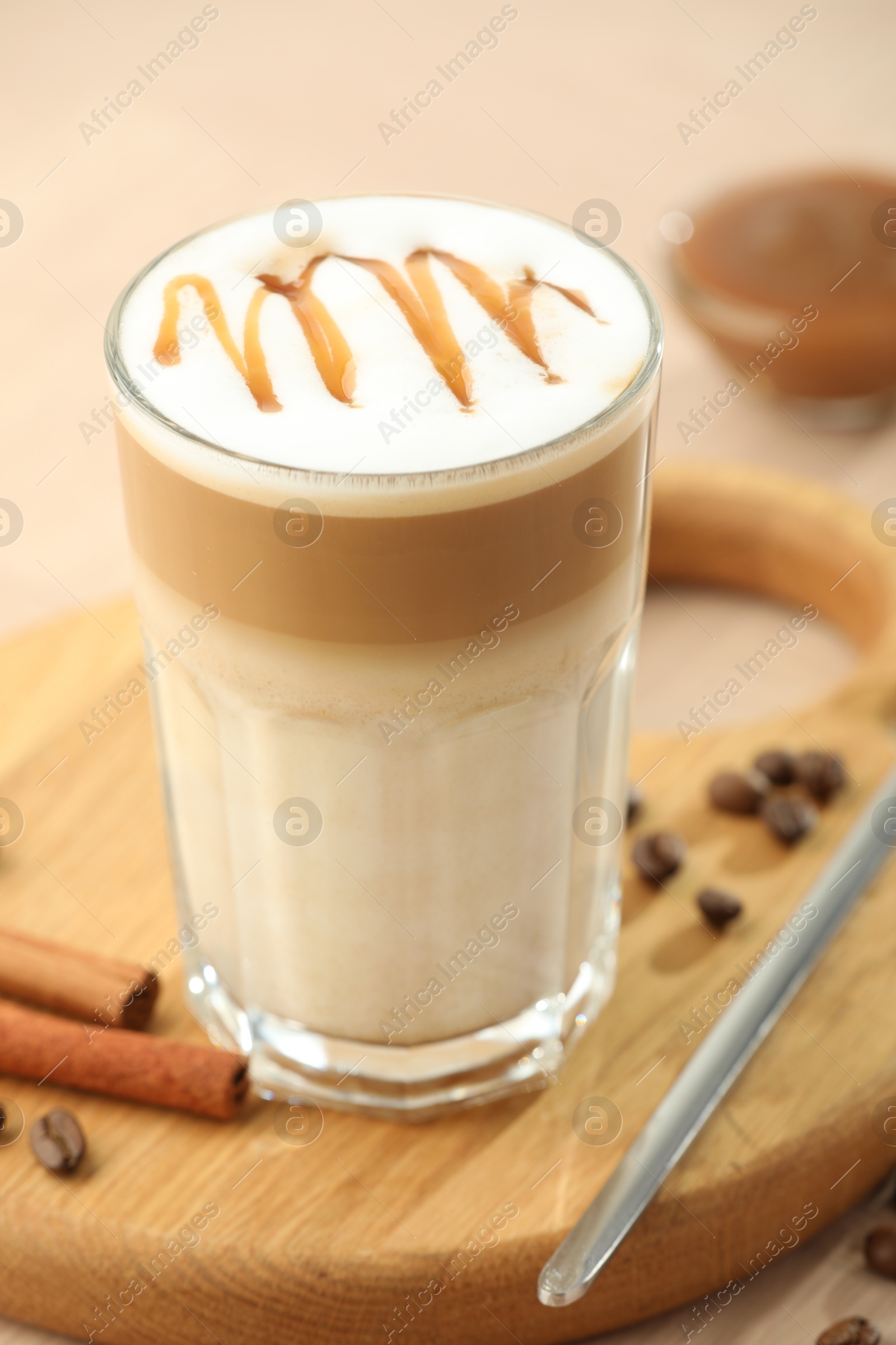 Photo of Tasty latte macchiato in glass on wooden table, closeup