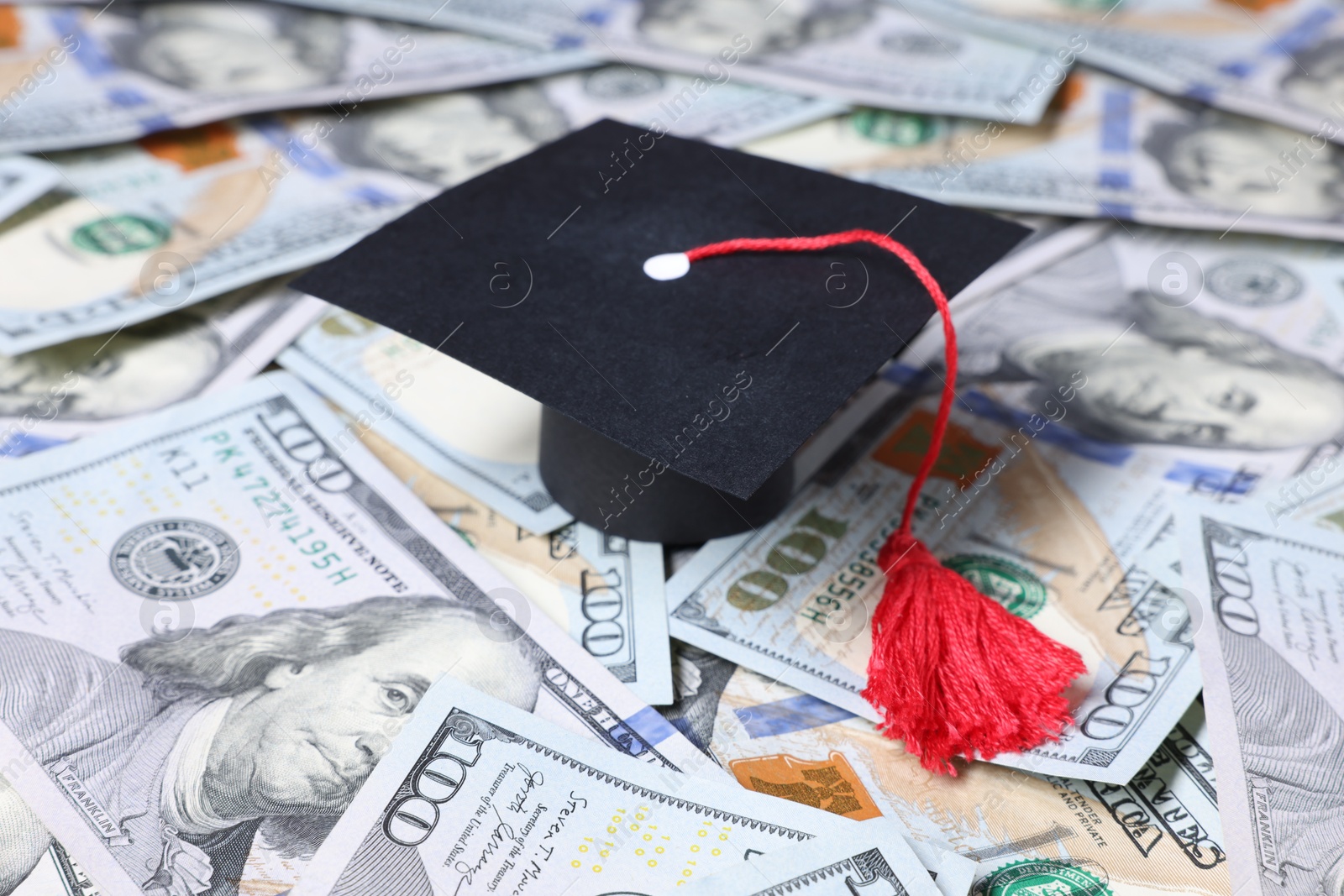 Photo of Graduate hat and dollars on table. Tuition payment