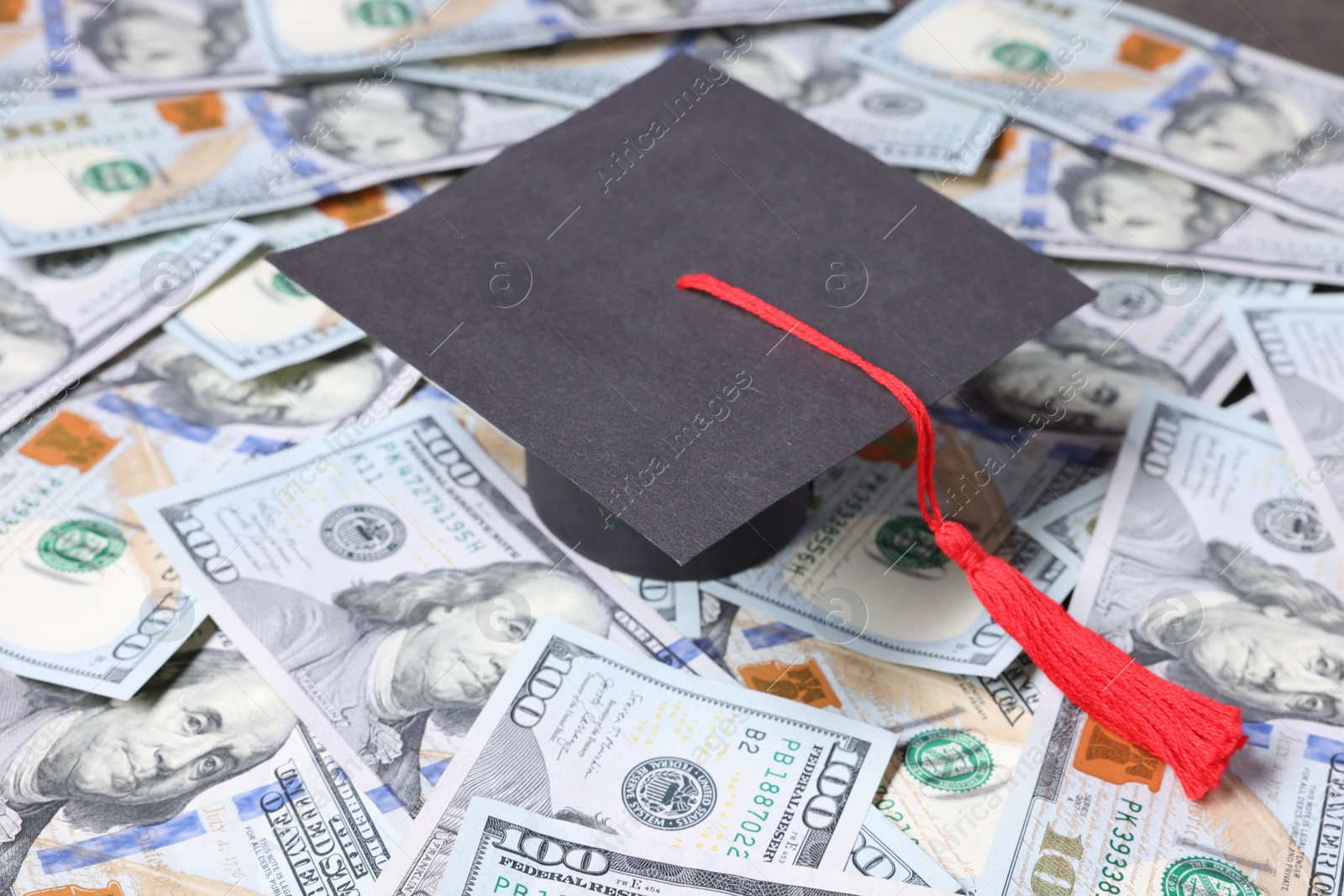 Photo of Graduate hat and dollars on table. Tuition payment