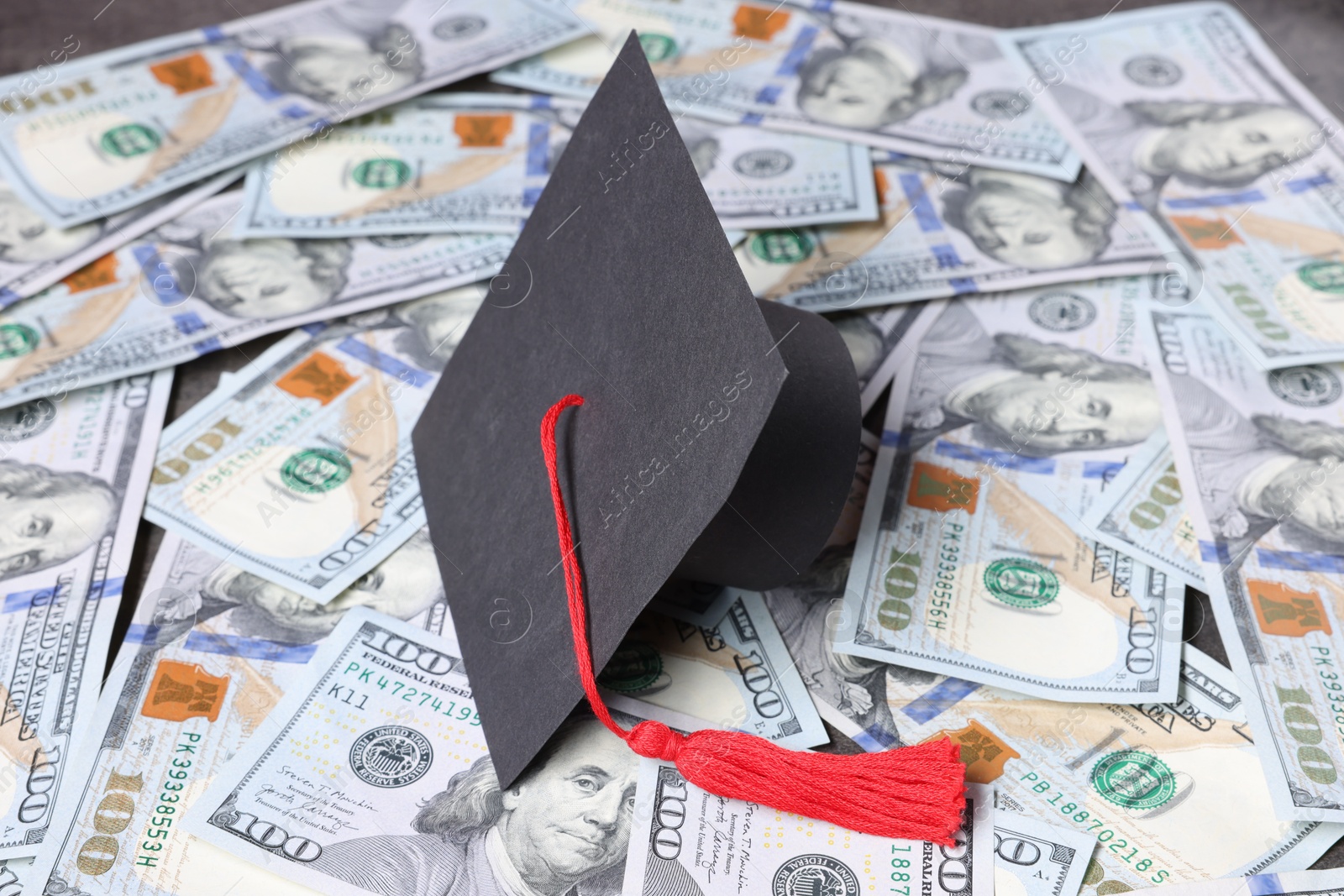 Photo of Graduate hat and dollars on table. Tuition payment