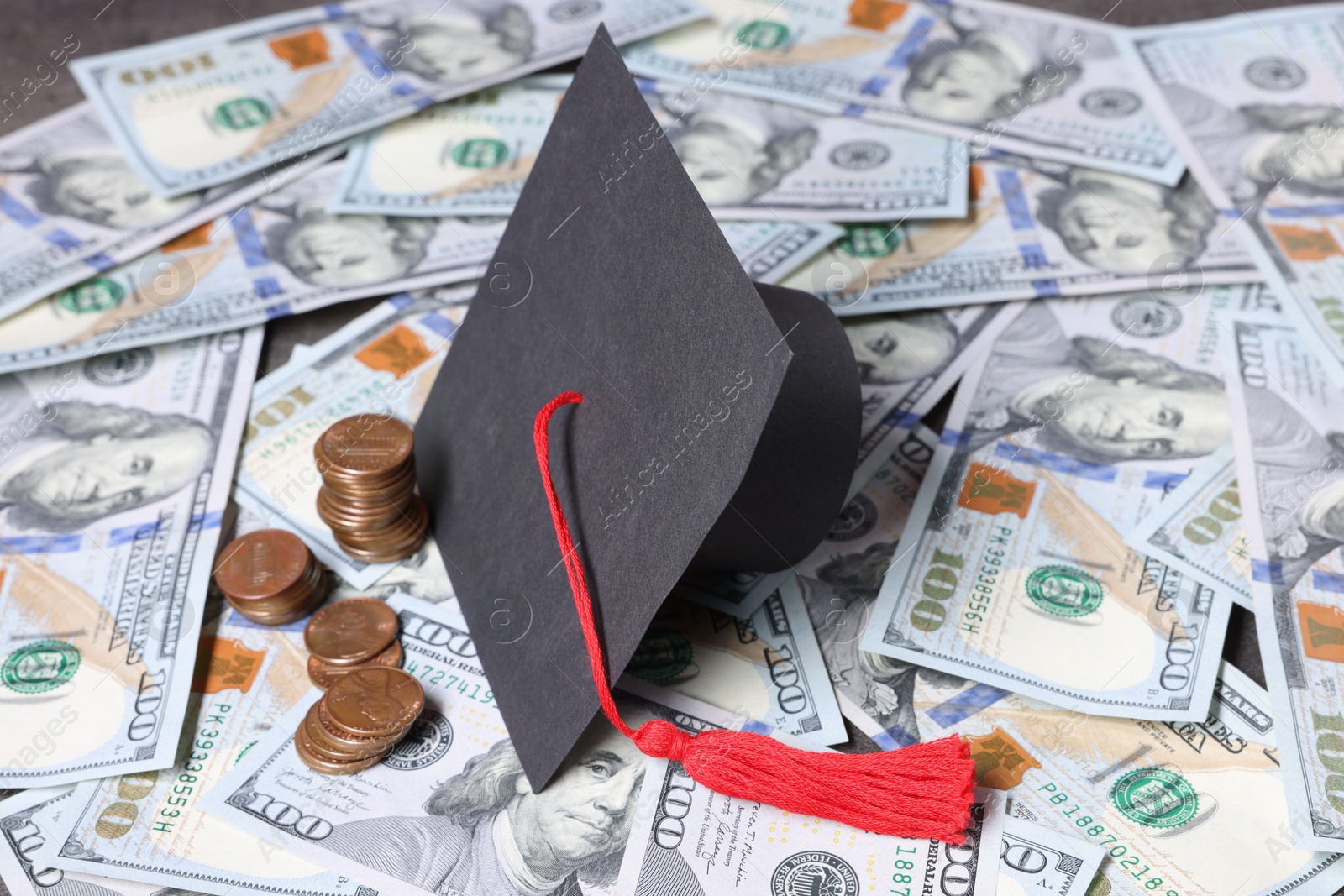 Photo of Graduate hat, dollars and coins on table. Tuition payment