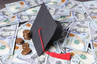 Photo of Graduate hat, dollars and coins on table. Tuition payment