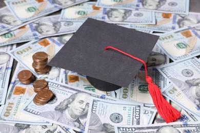 Photo of Graduate hat, dollars and coins on table. Tuition payment