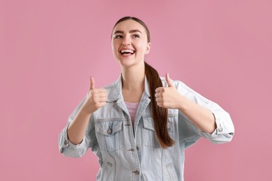 Photo of Happy woman showing thumbs up on pink background, space for text. Like gesture