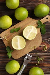 Photo of Lime zest, zester, mint leaves and fresh fruits on wooden table, flat lay