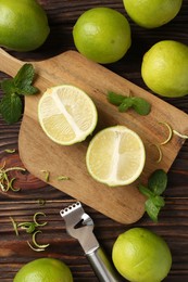 Photo of Lime zest, zester, mint leaves and fresh fruits on wooden table, flat lay