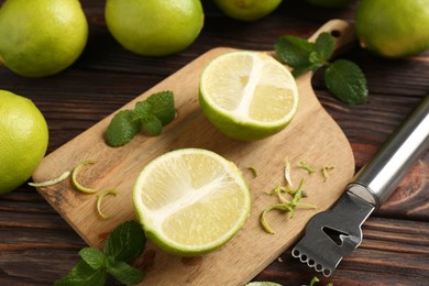 Photo of Lime zest, zester, mint leaves and fresh fruits on wooden table, closeup