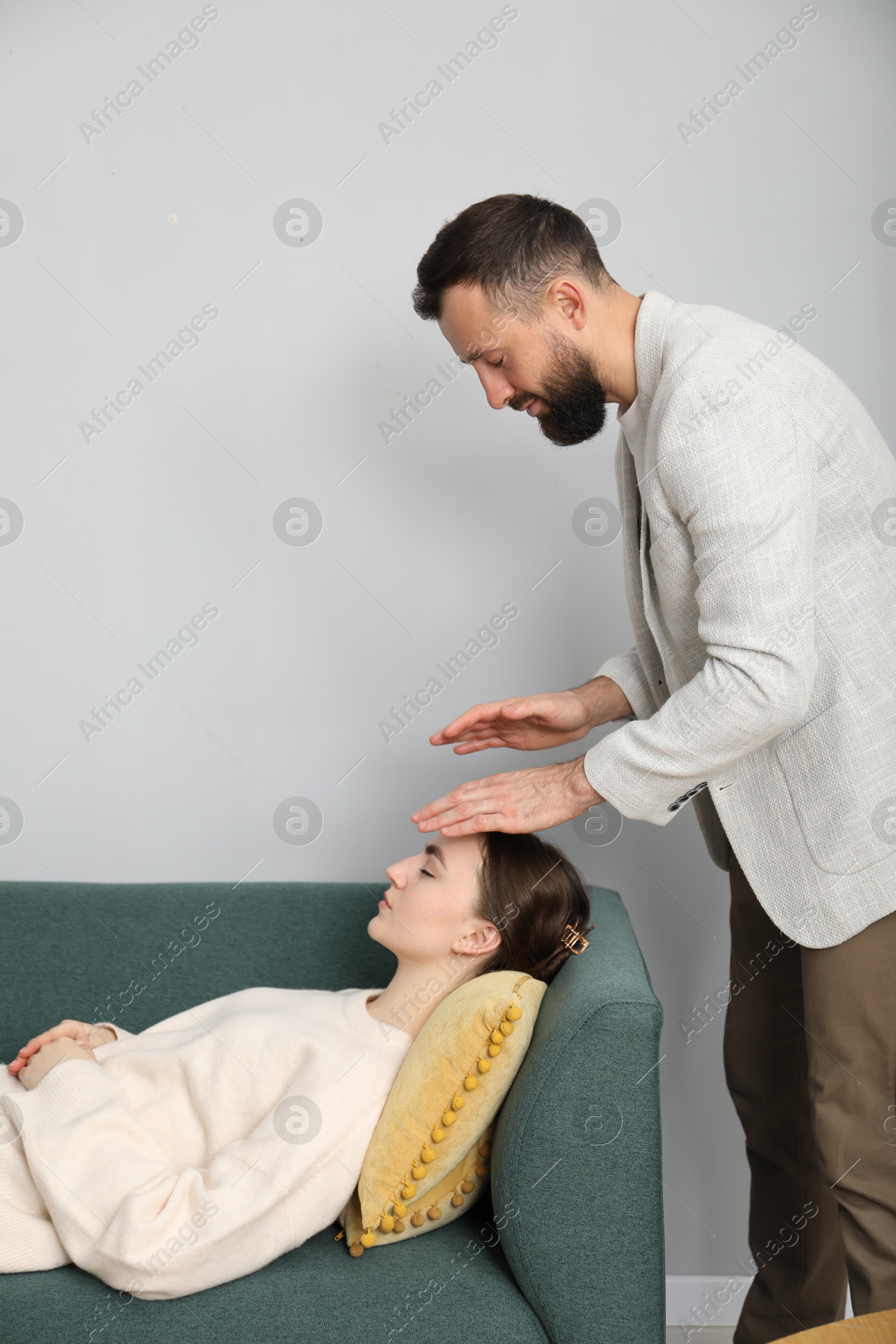 Photo of Psychologist working with patient during hypnosis session indoors