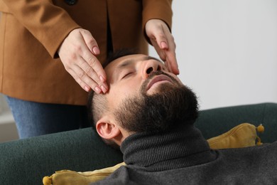 Photo of Psychologist working with patient during hypnosis session indoors, closeup