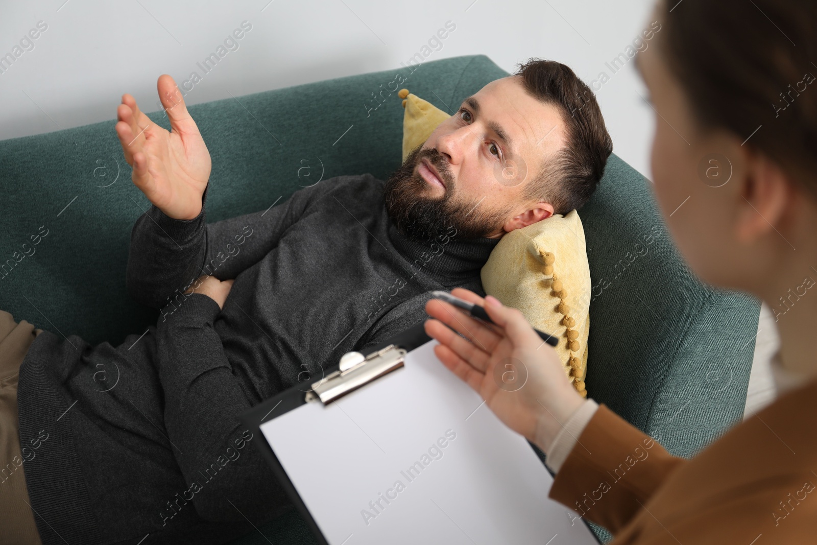 Photo of Psychologist working with patient during hypnosis session indoors, closeup