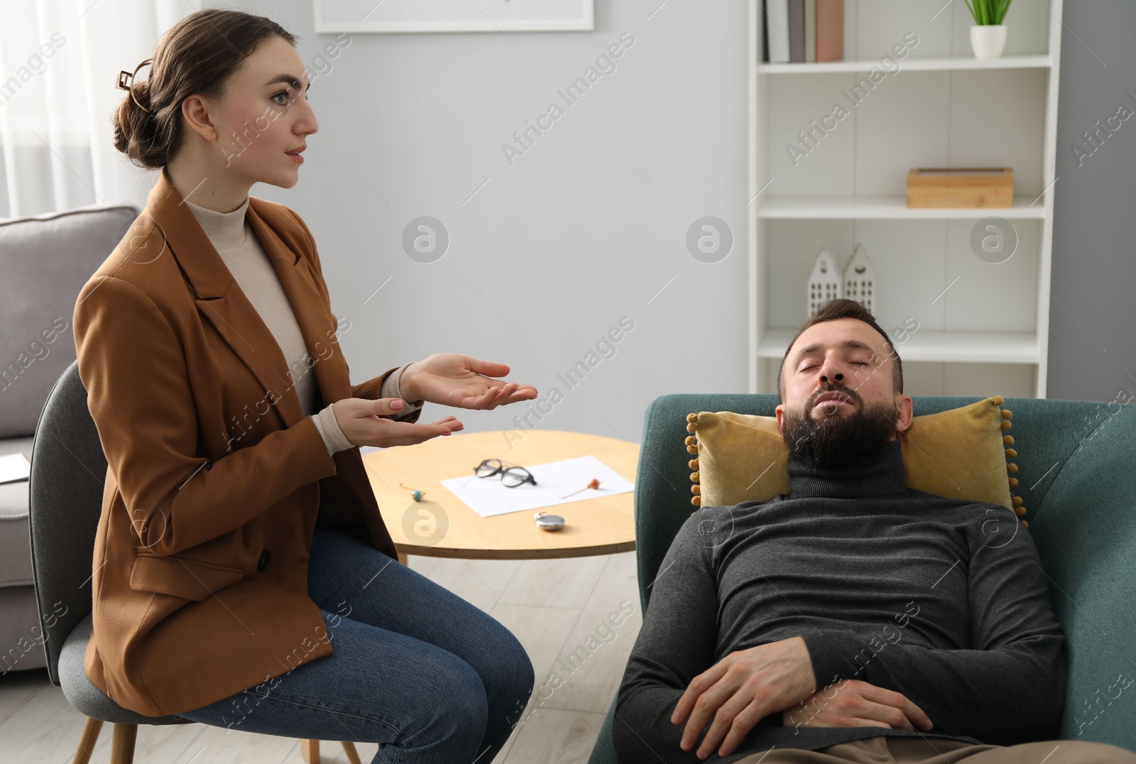 Photo of Psychologist working with patient during hypnosis session indoors