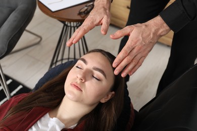 Photo of Psychologist working with patient during hypnosis session indoors, closeup