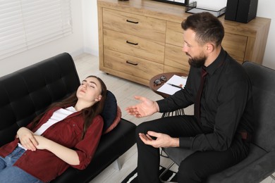 Photo of Psychologist working with patient during hypnosis session indoors