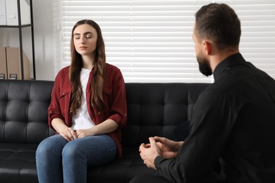 Photo of Psychologist working with patient during hypnosis session indoors