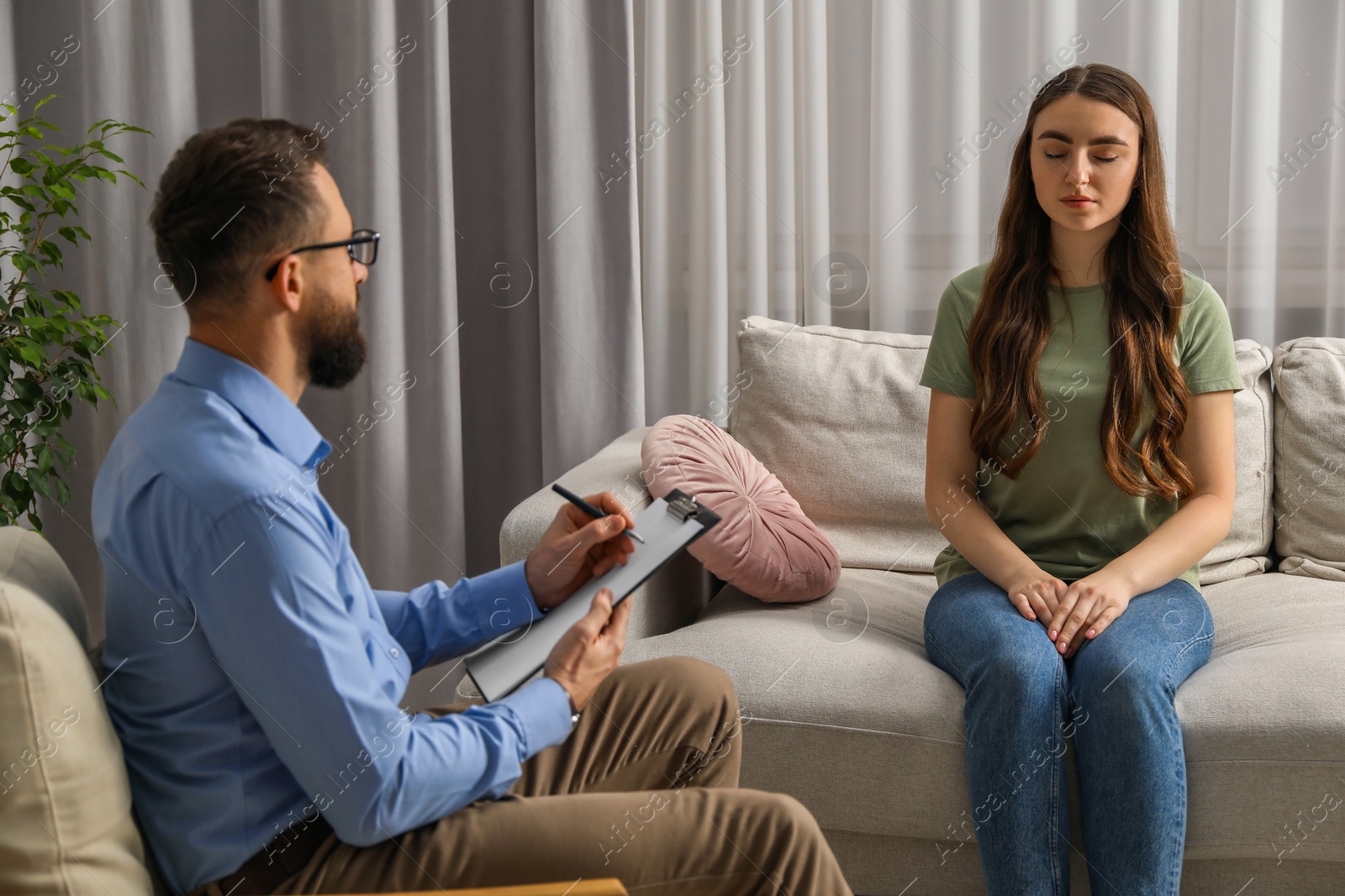 Photo of Psychologist working with patient during hypnosis session indoors