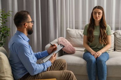 Photo of Psychologist working with patient during hypnosis session indoors