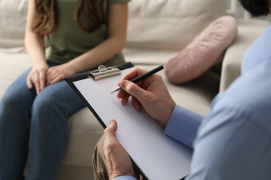 Photo of Psychologist working with patient during hypnosis session indoors, closeup