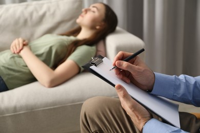 Photo of Psychologist working with patient during hypnosis session indoors, closeup