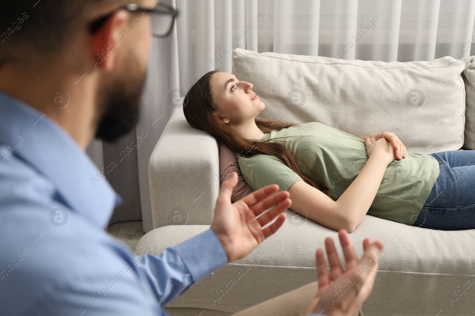 Photo of Psychologist working with patient during hypnosis session indoors, closeup