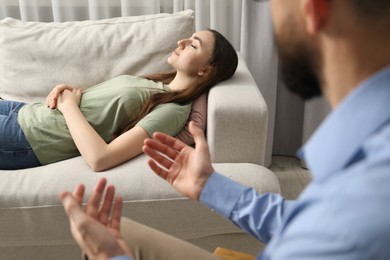 Photo of Psychologist working with patient during hypnosis session indoors, closeup