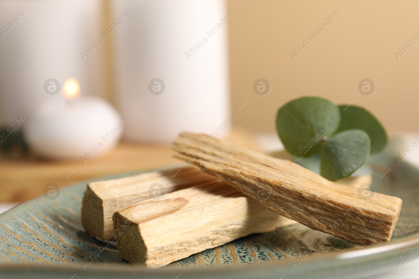 Photo of Palo santo sticks and eucalyptus leaves on table, closeup