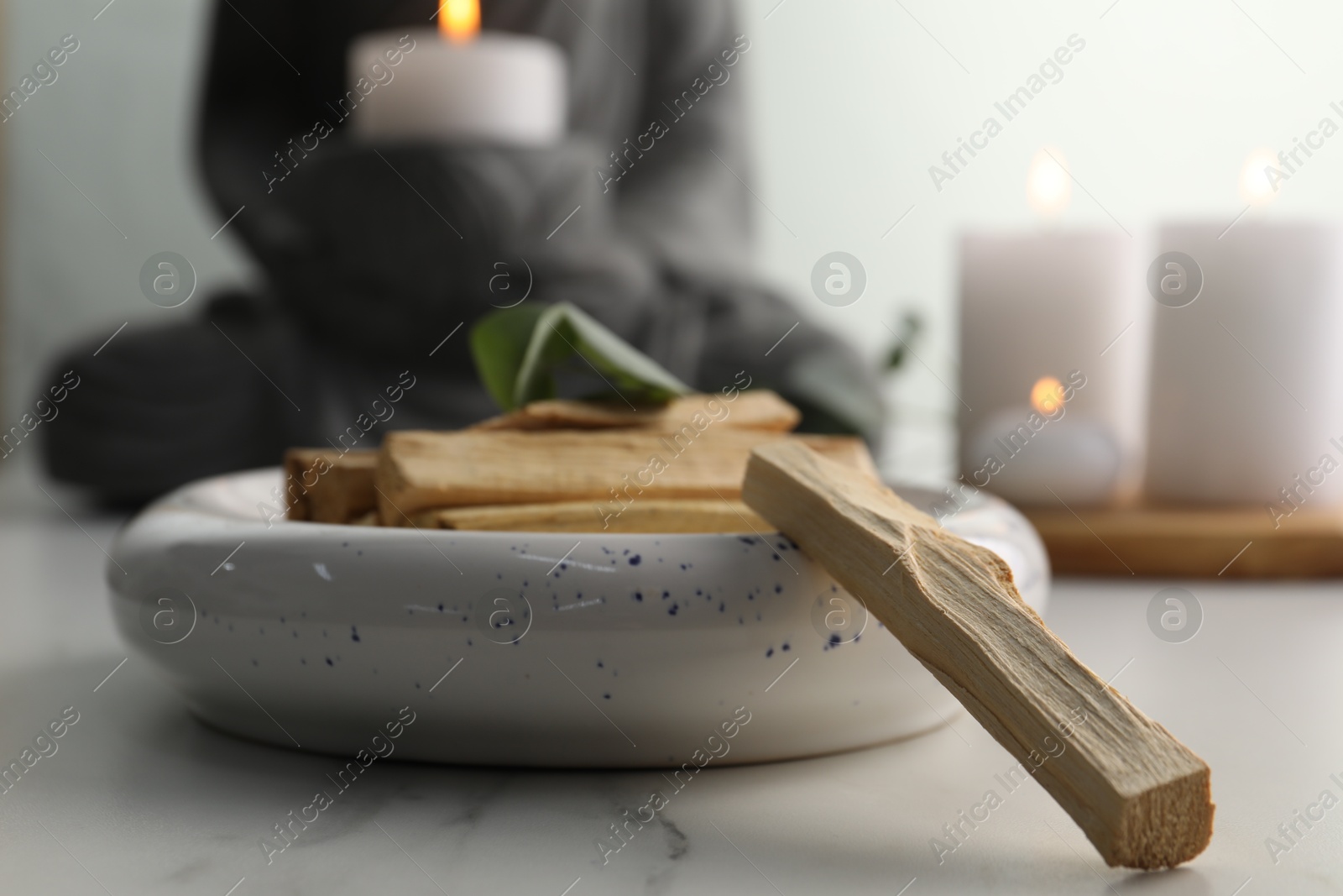 Photo of Palo santo sticks on white marble table, closeup