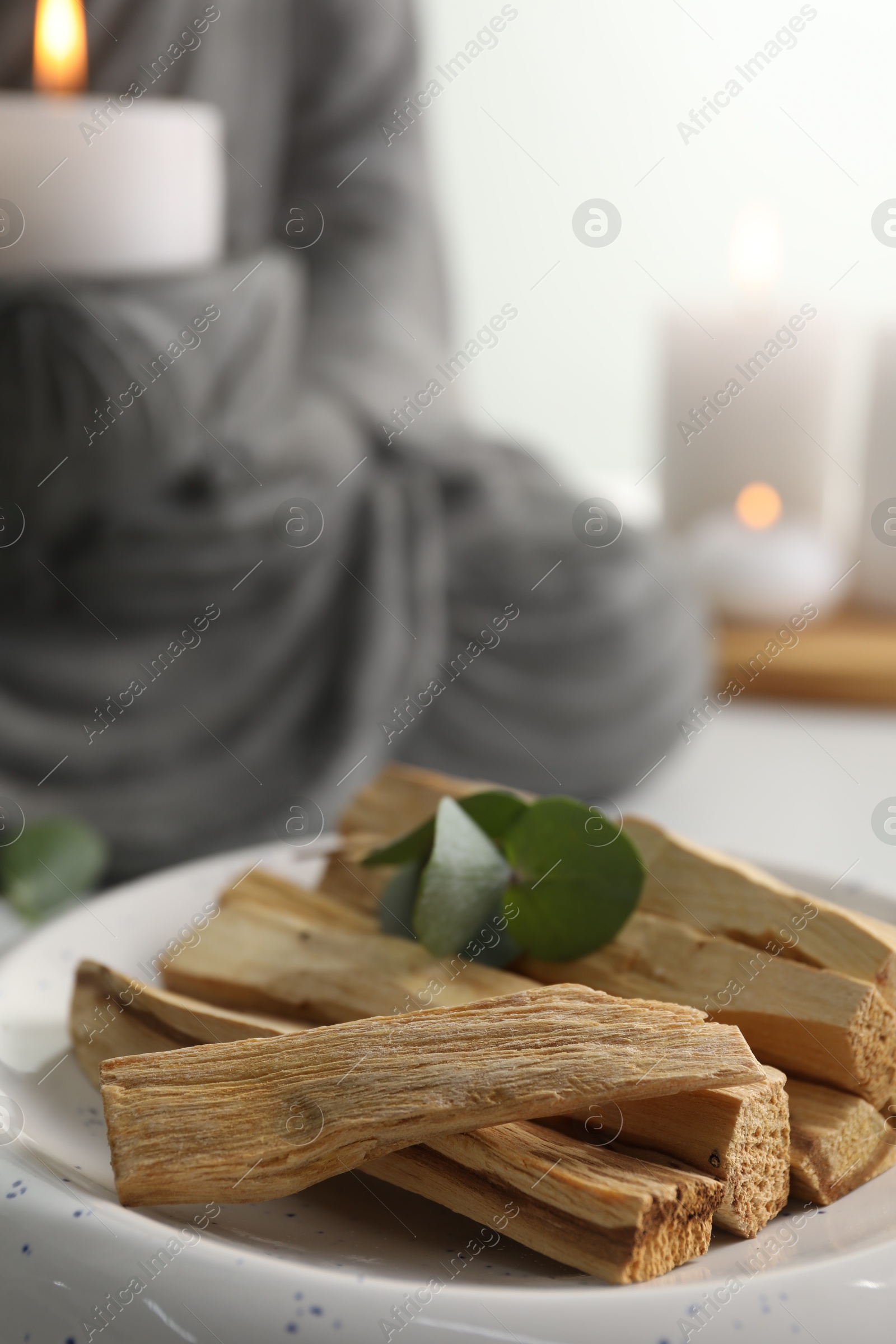 Photo of Palo santo sticks and eucalyptus leaves on table, closeup. Space for text