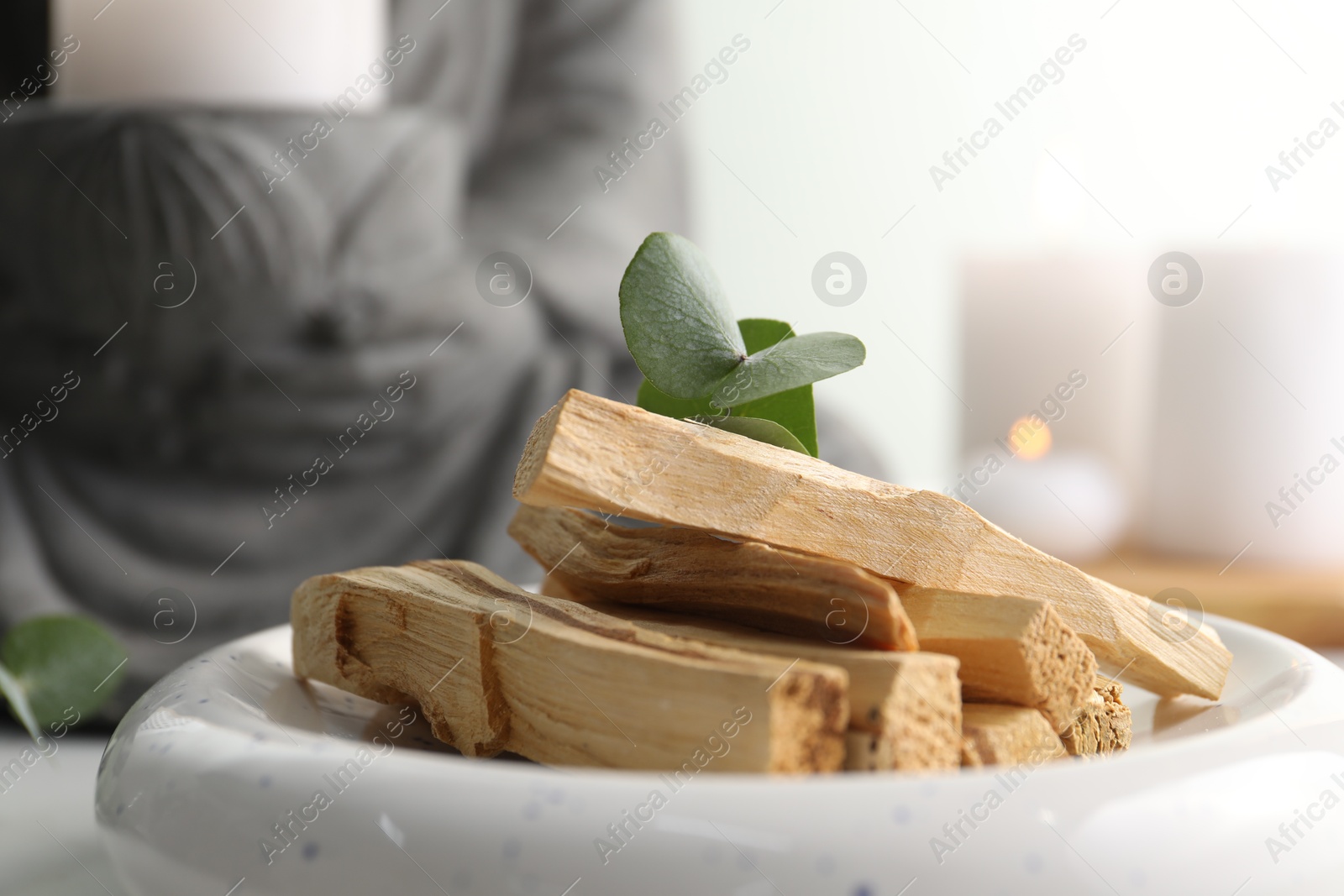 Photo of Palo santo sticks and eucalyptus leaves on table, closeup