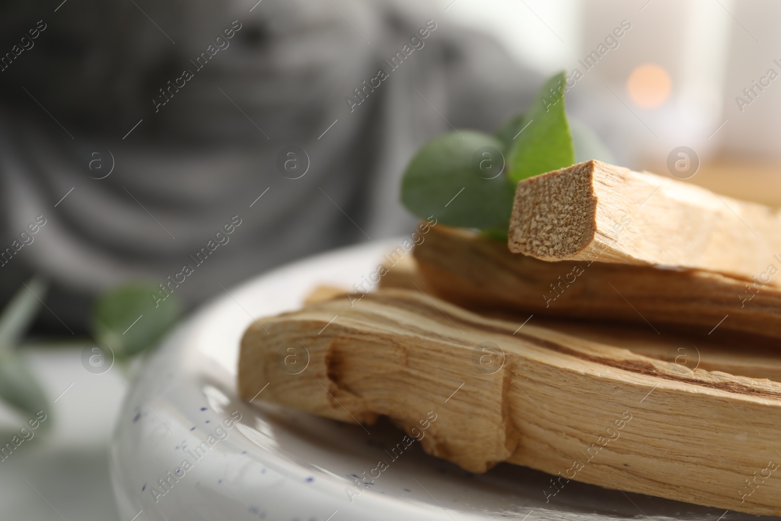 Photo of Palo santo sticks and eucalyptus leaves on table, closeup