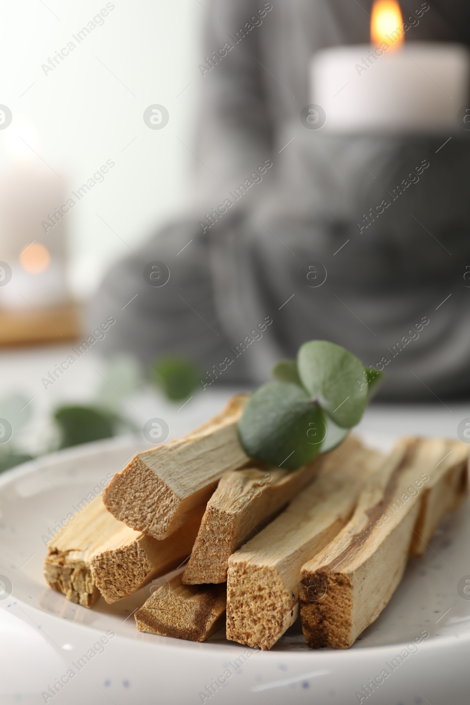 Photo of Palo santo sticks and eucalyptus leaves on table, closeup. Space for text