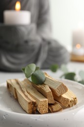 Photo of Palo santo sticks and eucalyptus leaves on table, closeup. Space for text