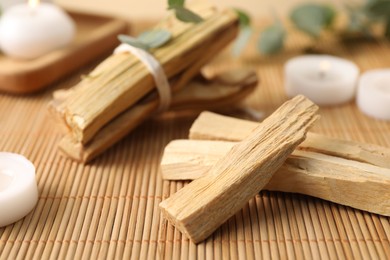 Photo of Palo santo sticks on bamboo mat, closeup