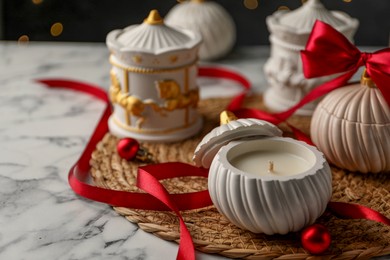 Photo of Soy wax candles on white marble table, closeup. Beautiful Christmas decor